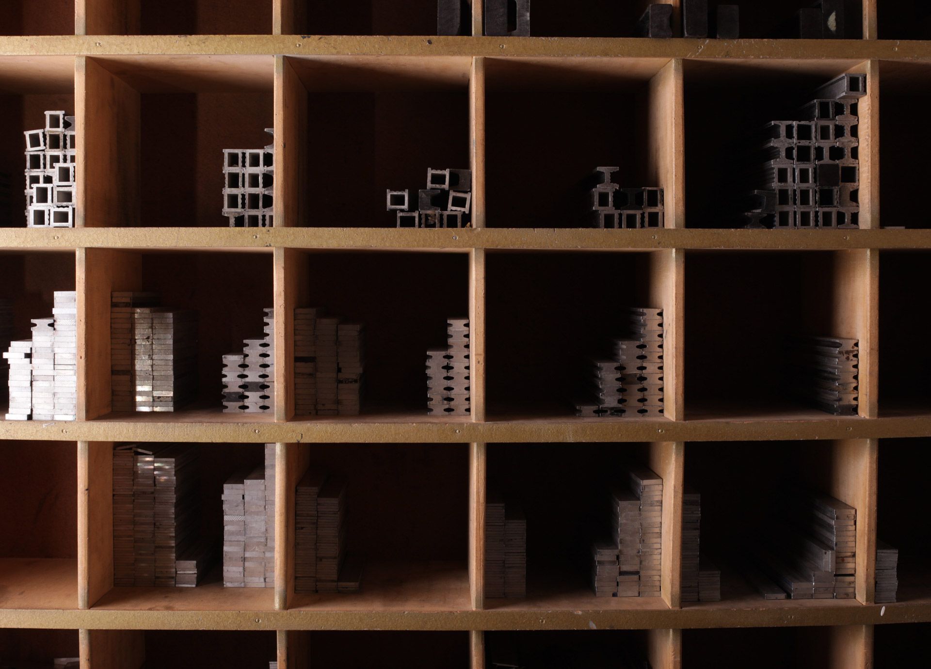 Collezione di scatole, brochure e materiali promozionali stampati su scaffali in legno.