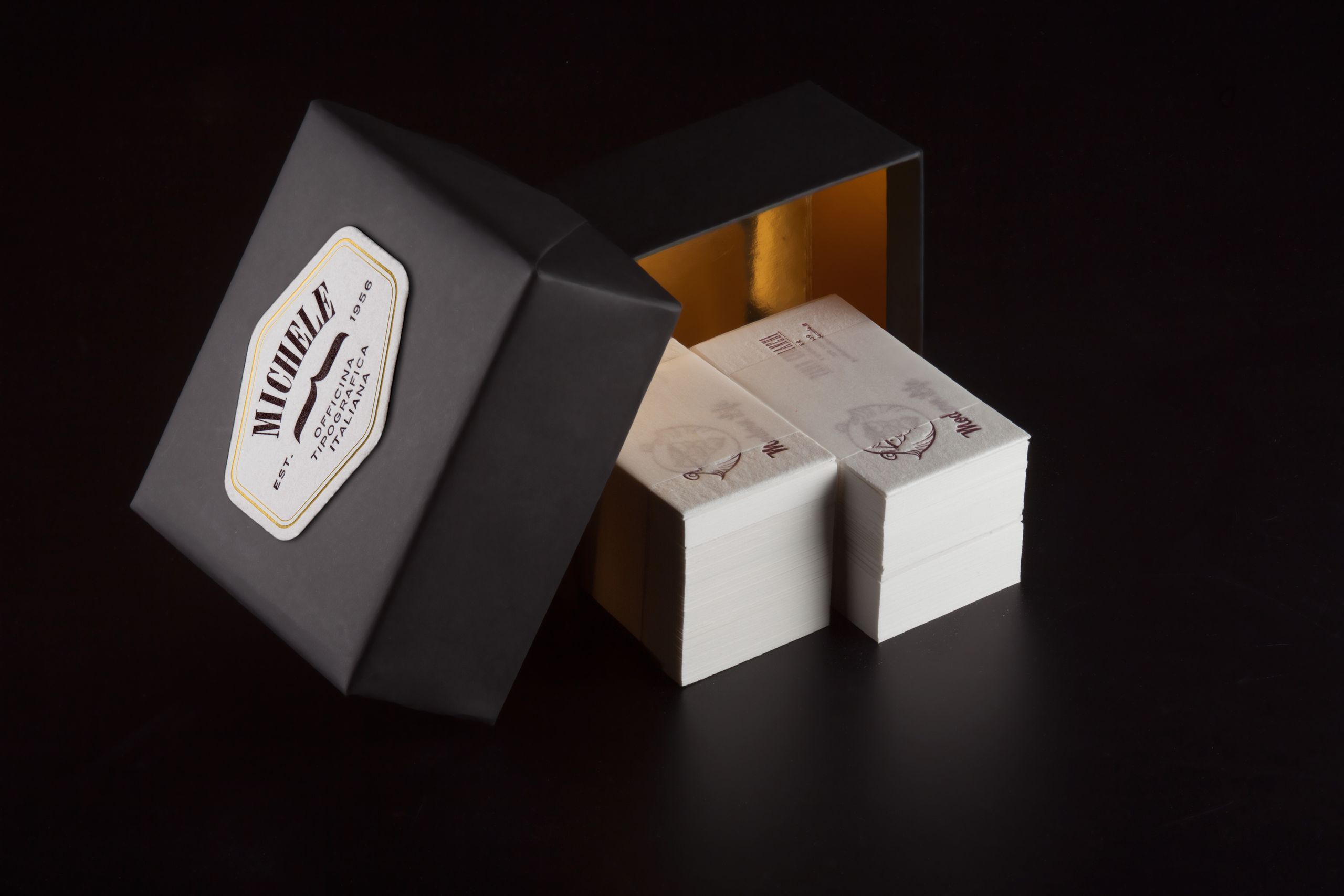 Scatola nera opaca con nastro dorato che dimostra le capacità di stampa e packaging di Sprint24.